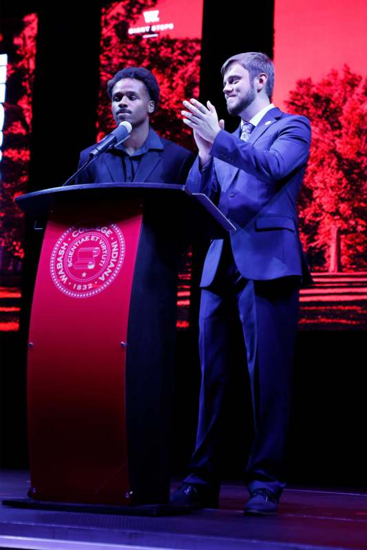 two men standing at a podium