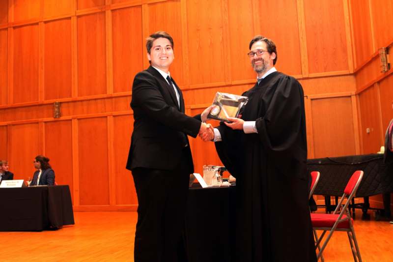 a man shaking hands with another man in a courtroom