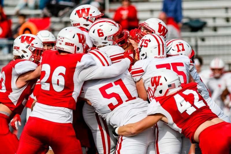 a group of football players huddle