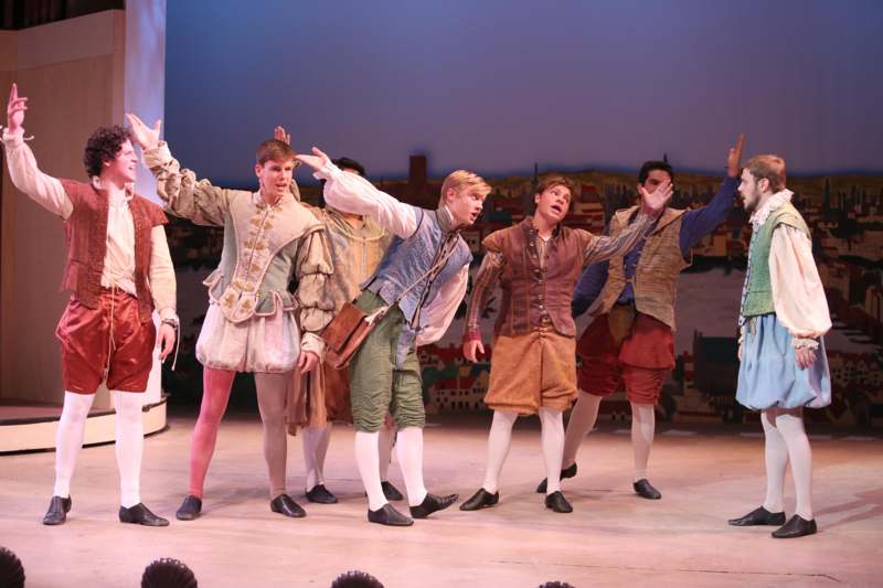 a group of men in clothing on a stage