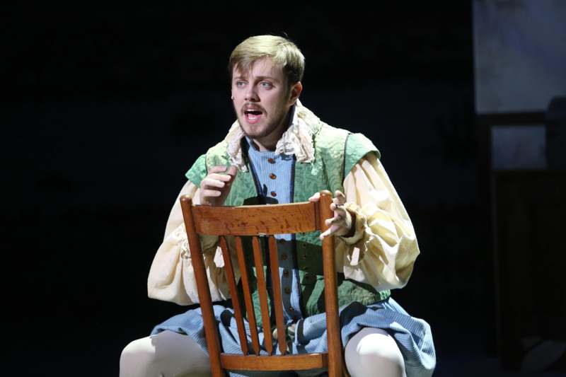 a man in a garment sitting on a chair