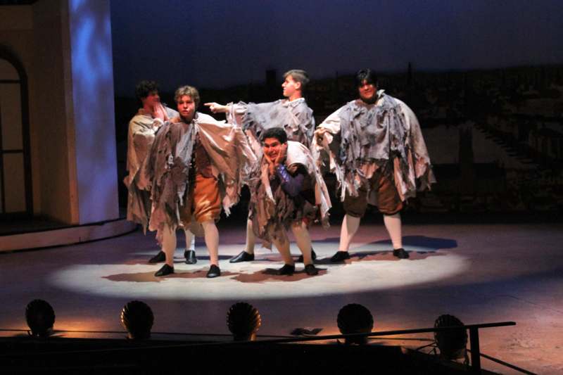 a group of men wearing clothing on a stage