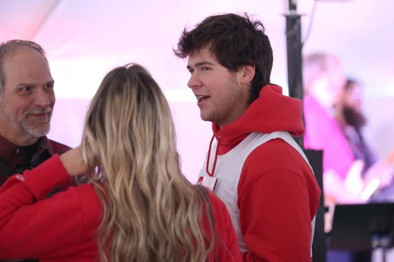 a man in red hoodie talking to a woman