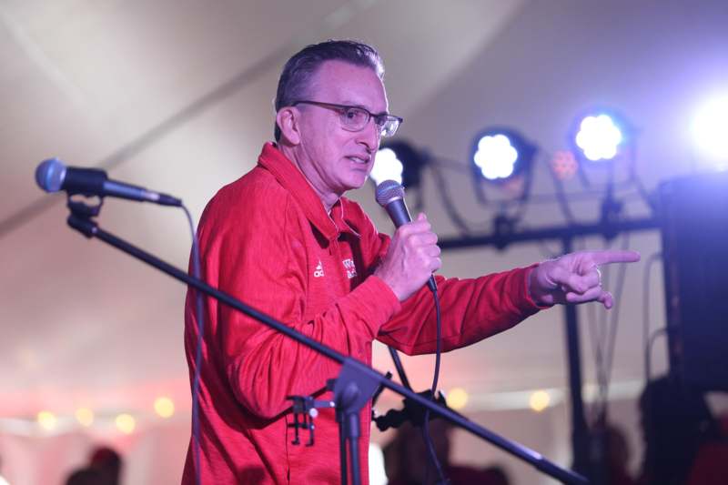 a man in red shirt holding a microphone