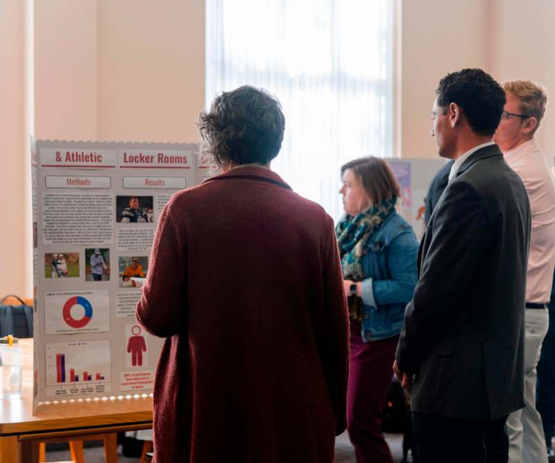 a group of people looking at a poster