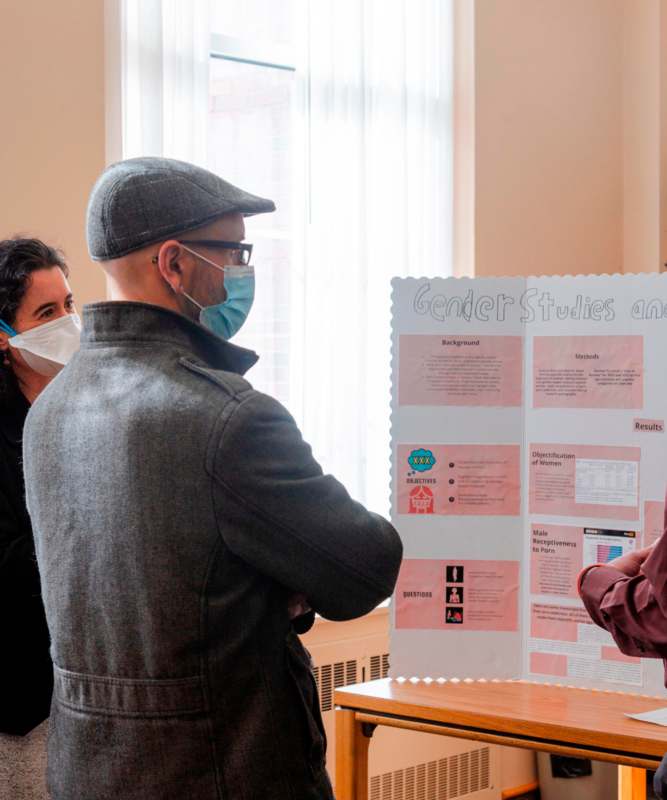 a group of people wearing face masks looking at a poster