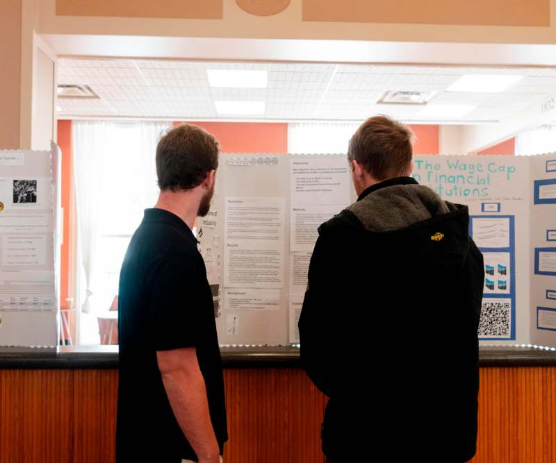 two men looking at a poster