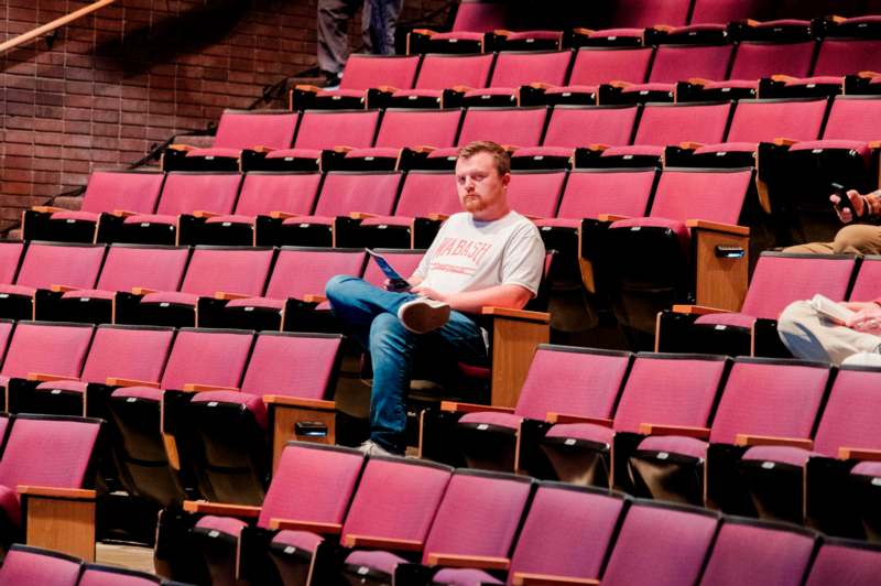 a man sitting in a chair in a auditorium