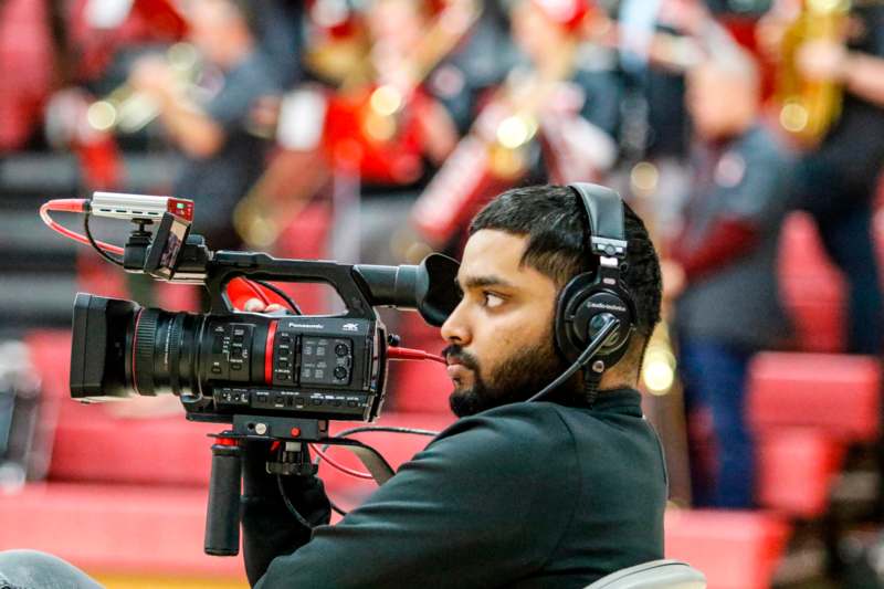 a man with headphones and a video camera