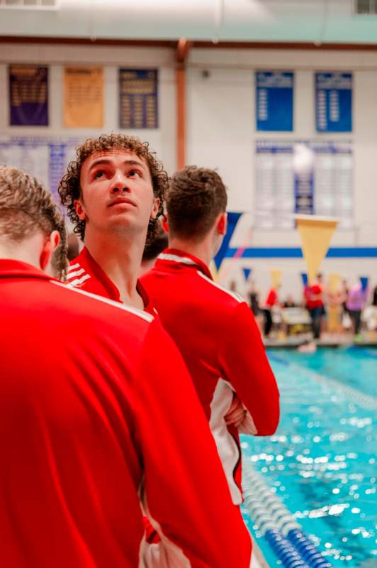 a group of men in red sports uniforms standing in a pool