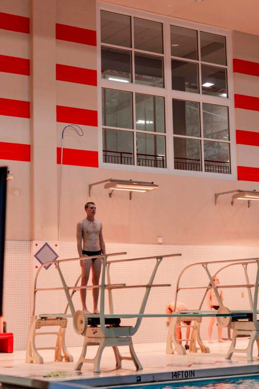 a man standing on a metal ladder in a swimming pool