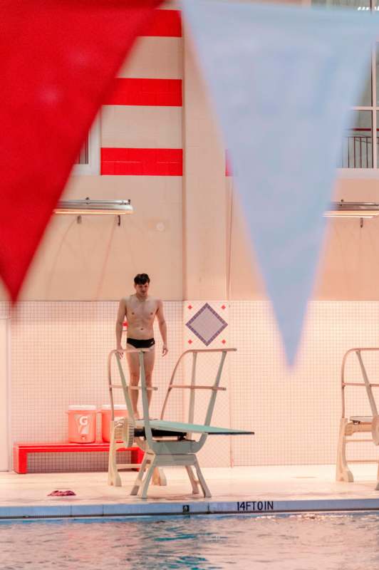 a man standing on a ladder in a swimming pool