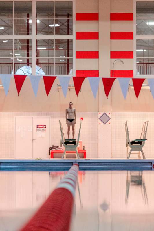 a man standing on a ladder in a swimming pool