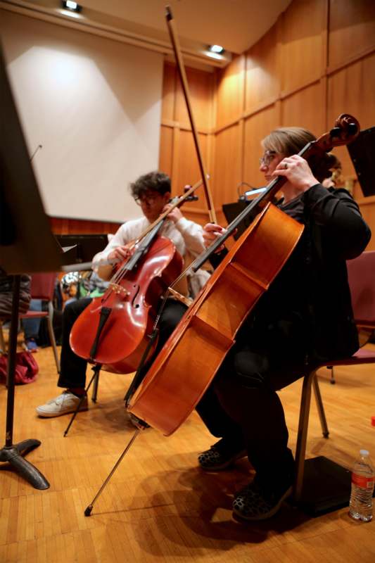 a group of people playing cellos