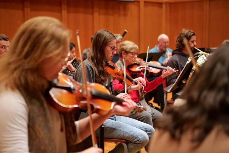 a group of people playing violins