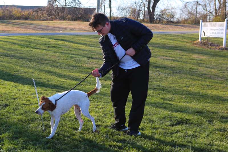 a man walking a dog on a leash in a park