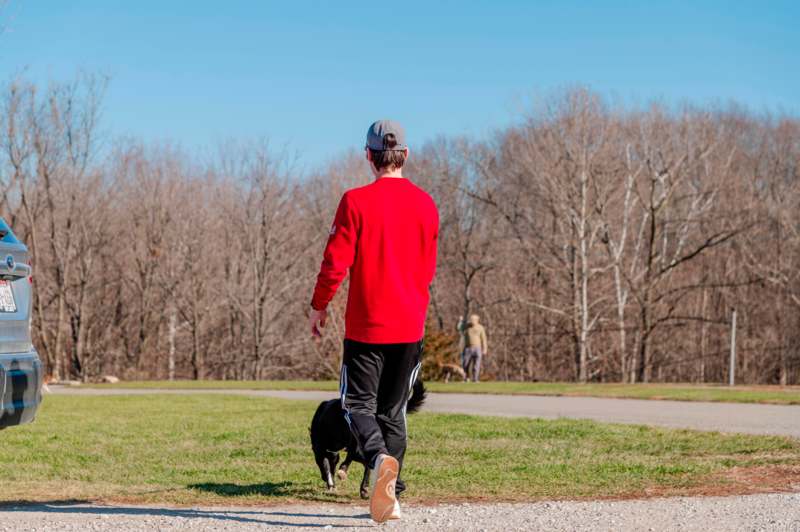 a man walking a dog in a park