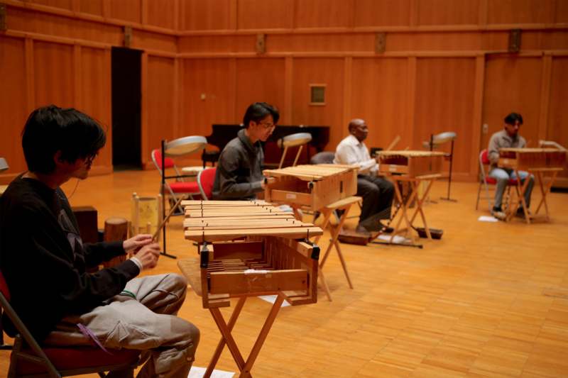 a group of people sitting in a room playing instruments
