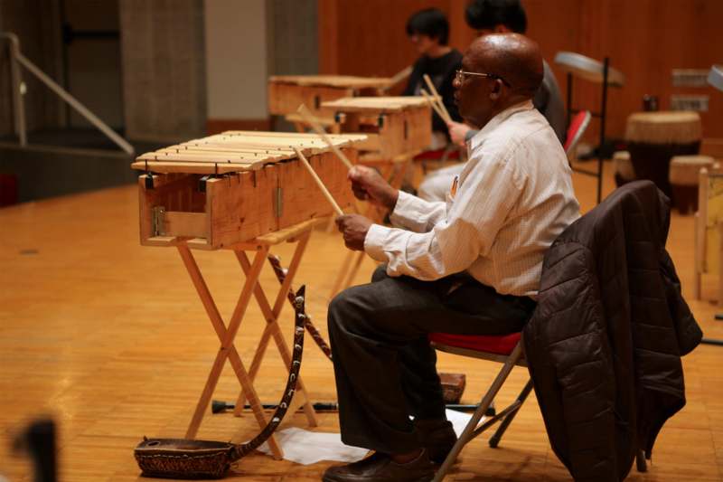 a man sitting in a chair playing an xylophone