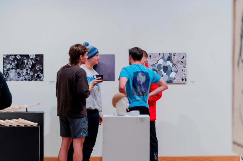a group of people looking at pictures on a wall