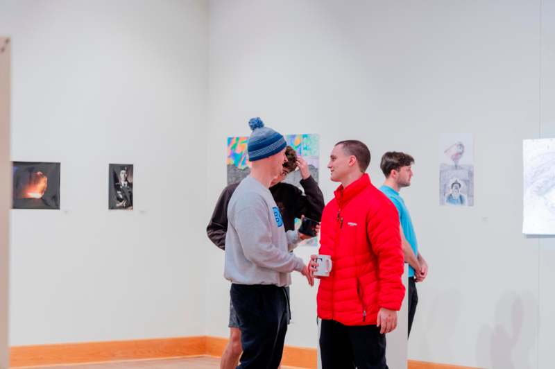 a group of men in a room with art on the wall