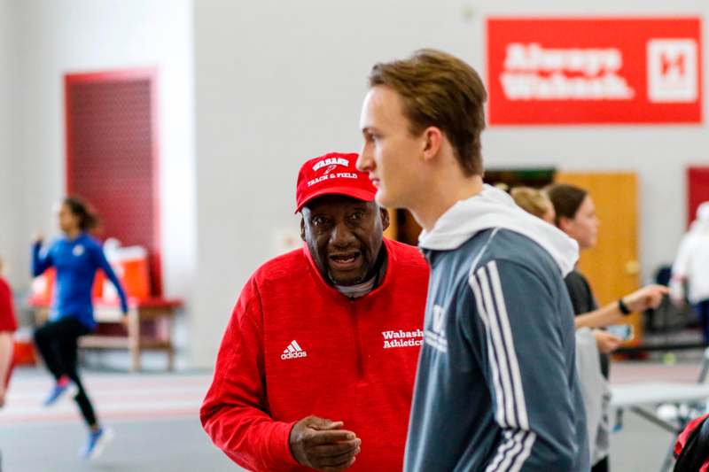 a man in a red hat talking to a young man