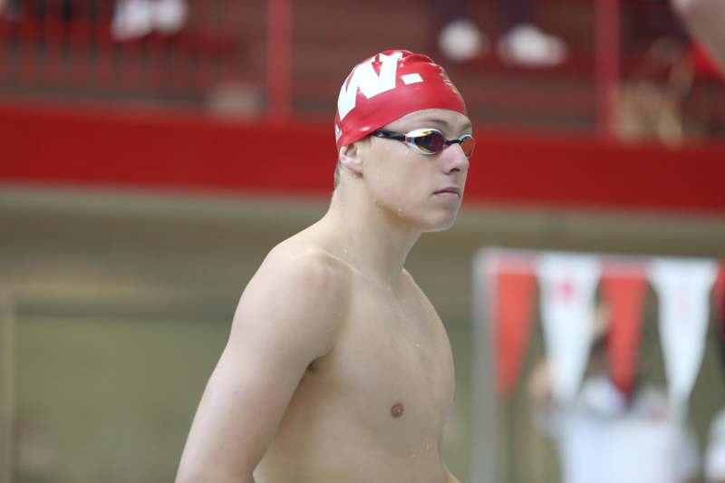 a man wearing goggles and a red swim cap