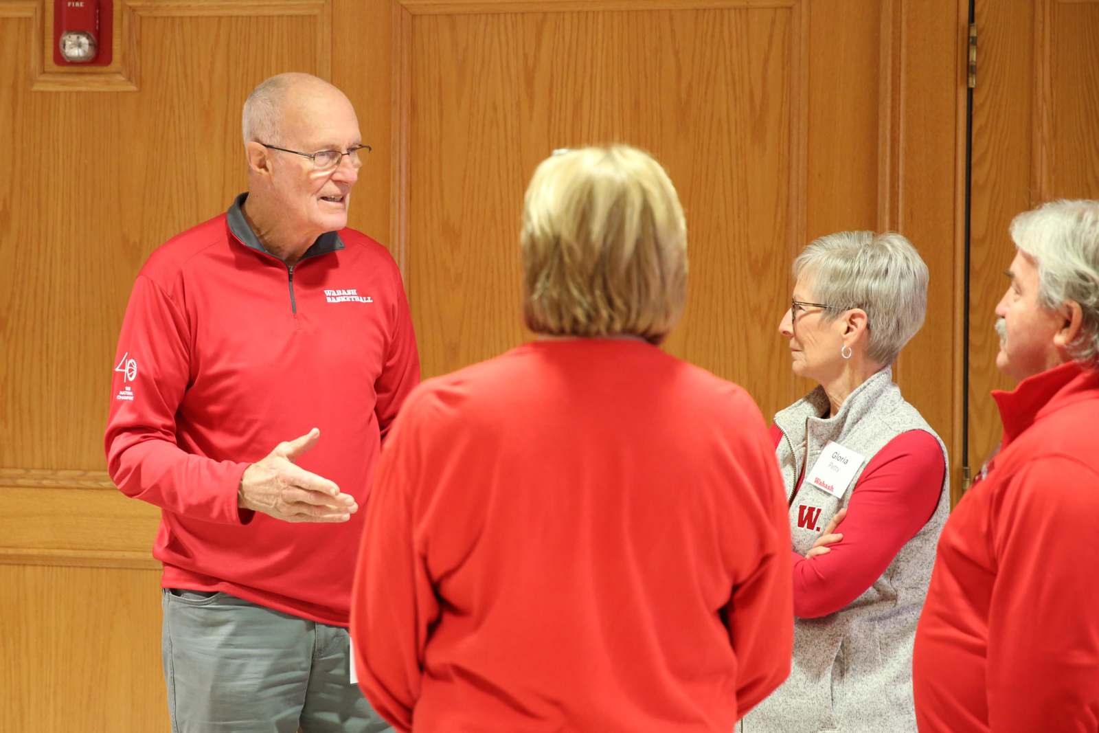 a man in red shirt talking to a group of people