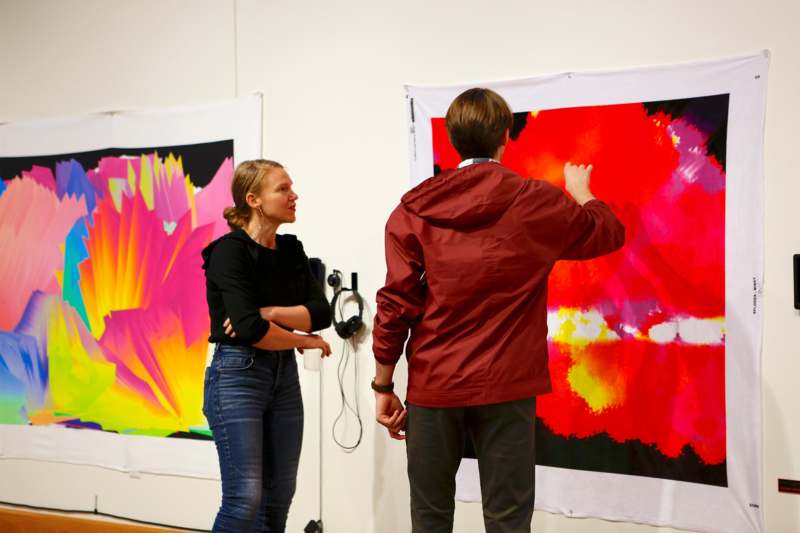 a man and woman looking at a painting