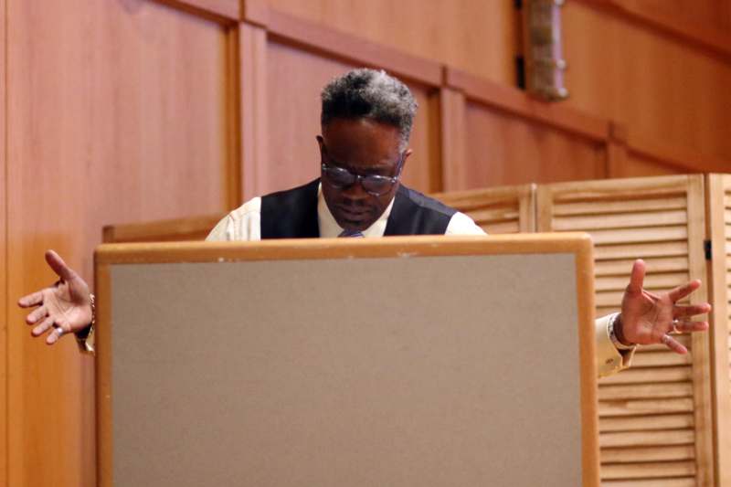 a man in glasses and a vest looking at a screen