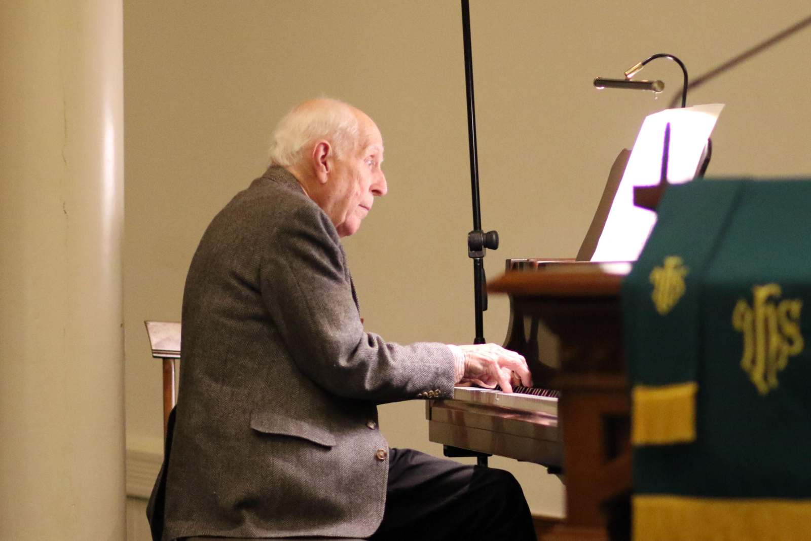 an old man playing a piano