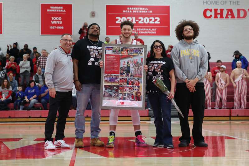 a group of people standing in a gym holding a poster