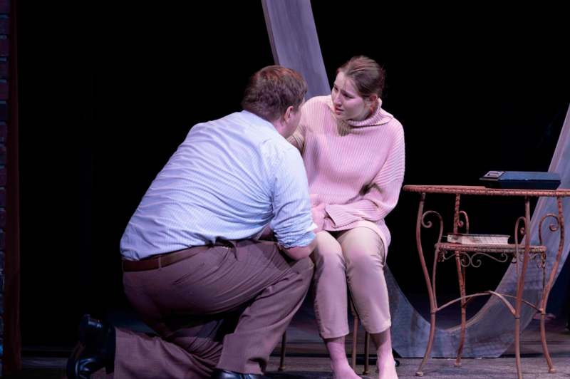 a man kneeling down to a woman on a stage