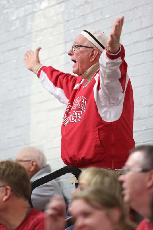 a man in a red jacket with his hands up