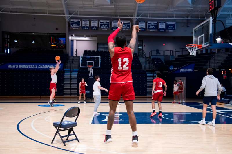 a basketball player in red uniform on a basketball court