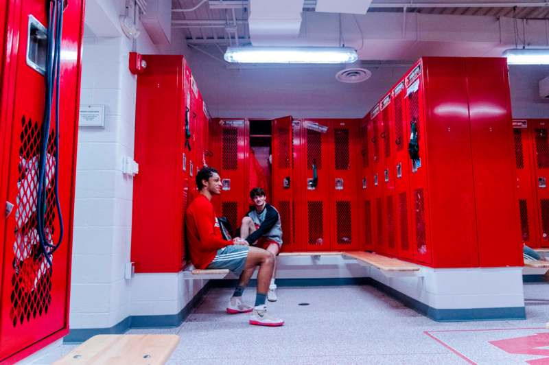 two men sitting in a locker room