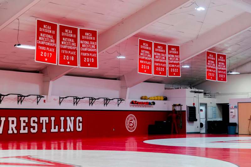 a red and white gym with signs and a wall