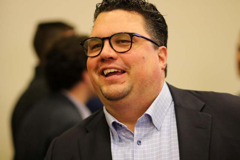 a man in a suit and glasses smiling