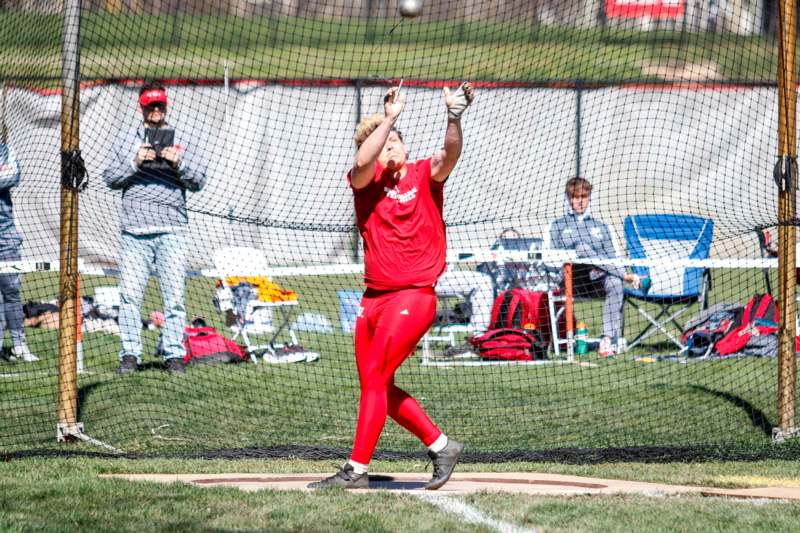 a man in red shirt throwing a ball