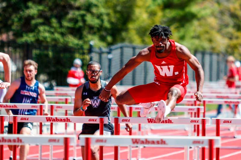 a man jumping over hurdles on a track