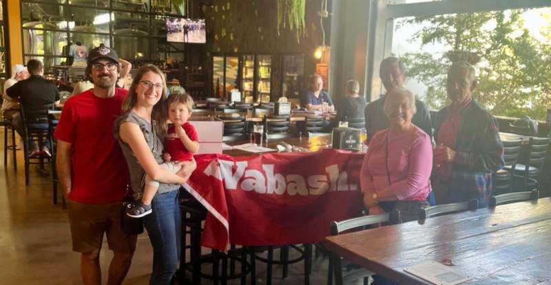 a woman holding a child and a woman standing in a restaurant
