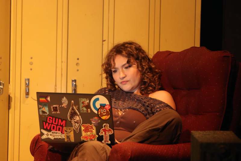 a woman sitting on a red chair with a laptop