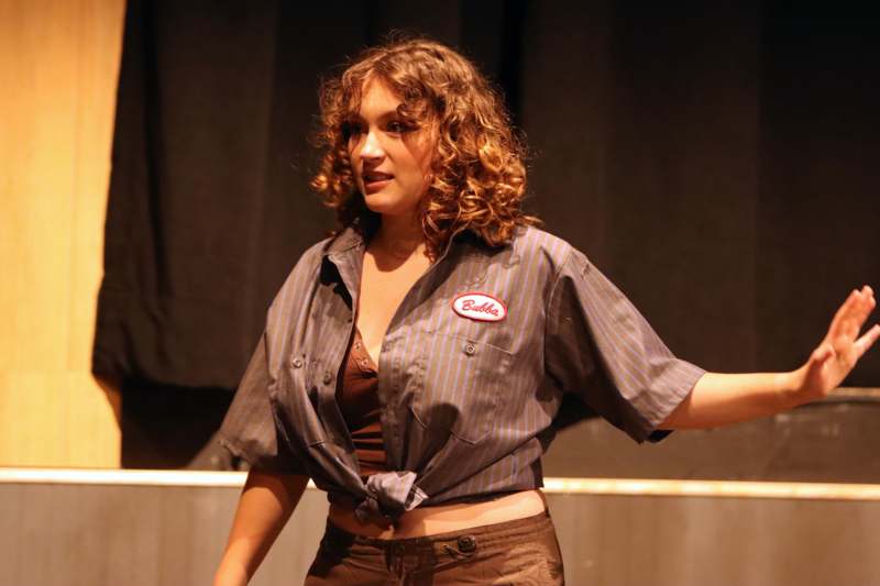 a woman with curly hair wearing a button up shirt