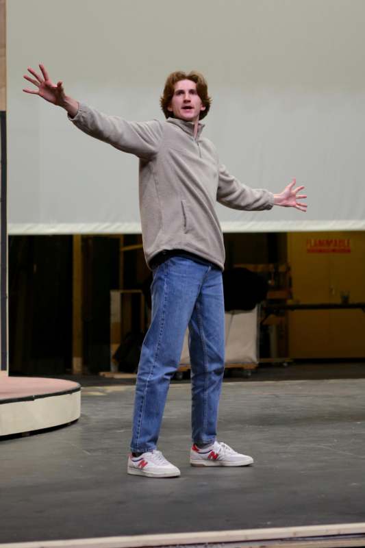 a man standing on a stage with his arms out