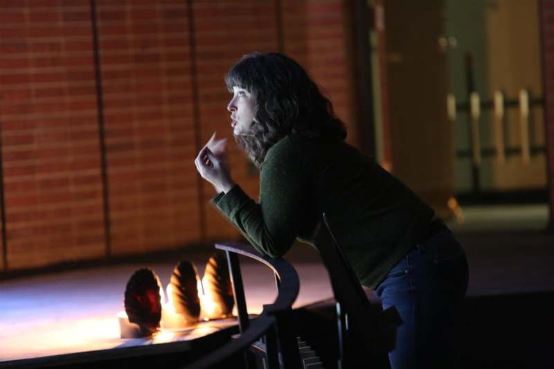 a woman standing in front of a table with candles