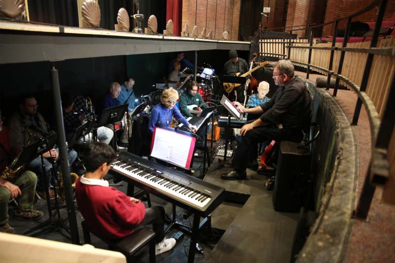 a group of people sitting around a piano