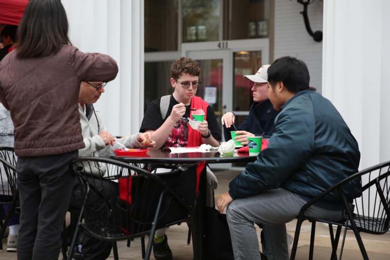a group of people sitting at a table outside