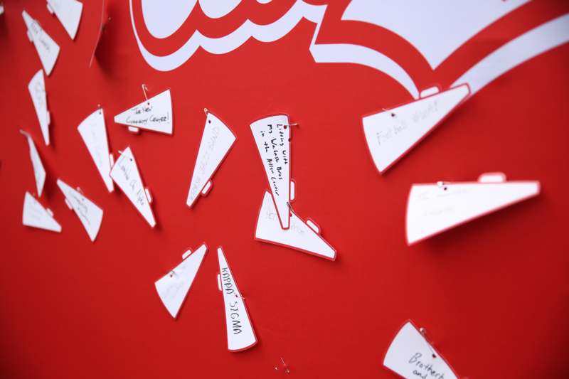 a group of white paper pieces on a red board