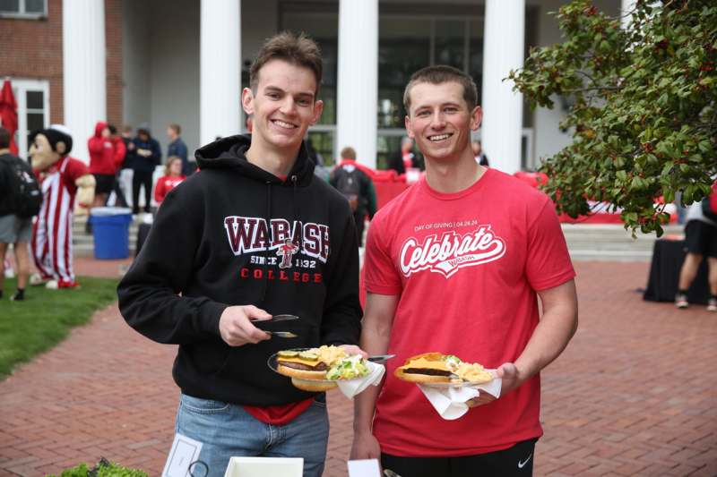 two men holding food in their hands