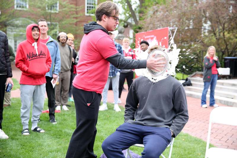 a man throwing a frisbee into another man's head